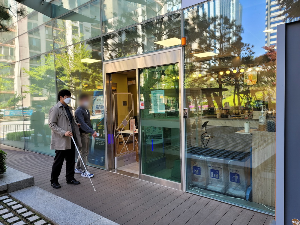 한국시각장애인연합회 김훈 연구원이 공공도서관에 입장하고 있다. 김훈 연구원은 점자블록조차 없기 때문에 도움 없이는 이동하기가 어려울 것 같다고 말했다.