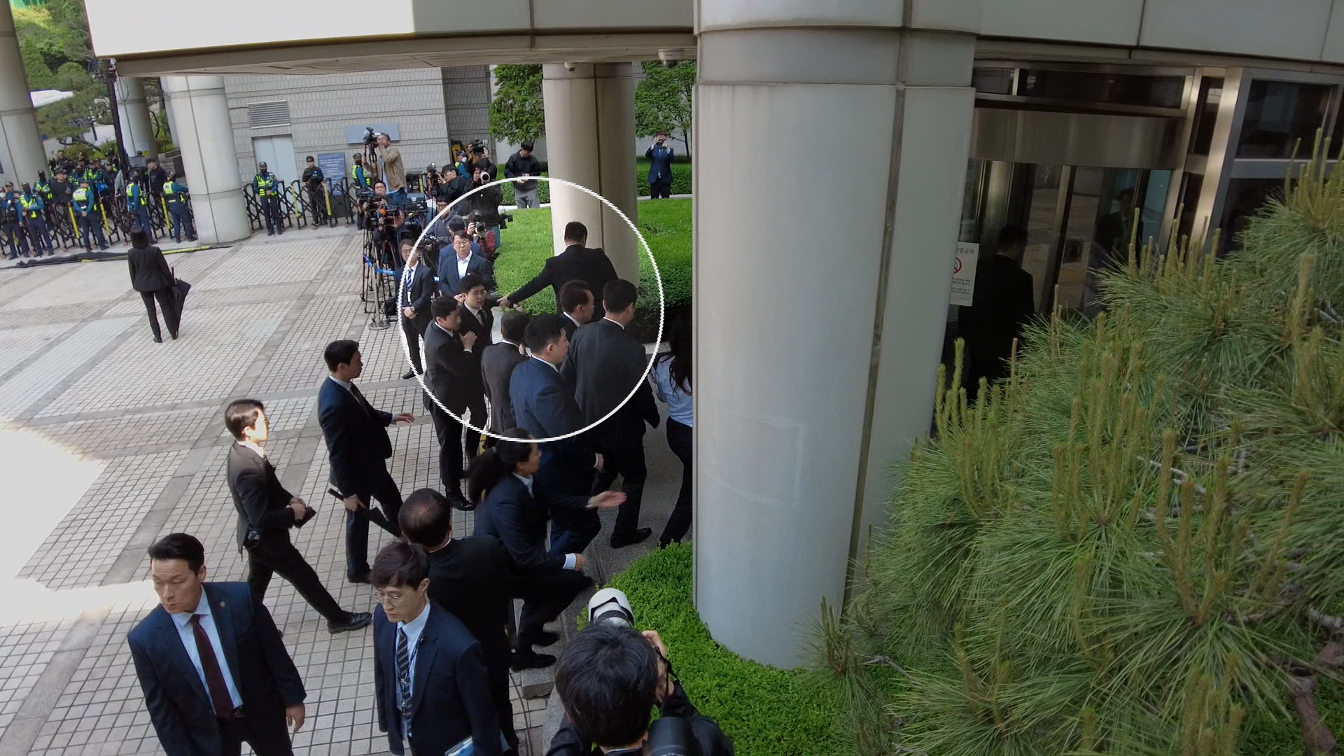 내란 우두머리 혐의로 재판을 받고 있는 윤석열 전 대통령이 처음으로 법원에 공개 출석하는 과정에서, 경호원들은 윤 전 대통령에게 질문하려는 KBS 기자의 두 팔과 허리 등을 강하게 잡아 끌며 취재를 방해하고 있다. 편집 : 김종선