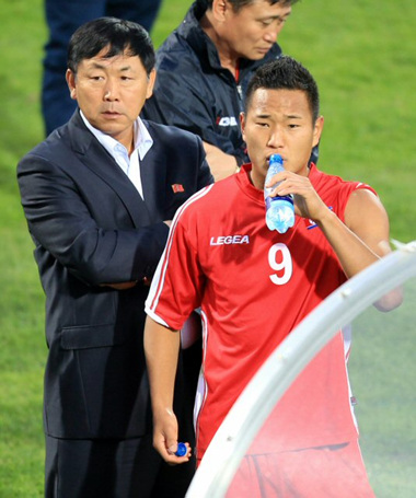7일 새벽 (한국시간) 남아공 요하네스버그 동쪽 템비사 마쿨롱 경기장에서 열린 나이지리아와 북한의 평가전에서 후반 초반 일부 관중이 선수단 통로 쪽 난간을 넘어와 매달려 있자 경기감독관이 안전 문제를 이유로 경기를 잠시 중단했다. 사진은 경기장 밖으로 나온 정대세가 김정훈 감독과 함께 관중석을 바라보고 있는 모습.