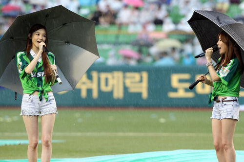 24일 대구시민운동장에서 열린 2010 프로야구 올스타전 이스턴리그-웨스턴리그 경기 전, 다비치가 빗속에 우산을 들고 축하공연을 하고 있다.