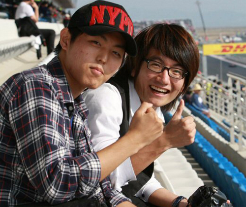 F1 코리아 그랑프리가 개막한 22일 전남 영암 F1경주장에서 대학생 신순원씨와 권오혁씨가 F1머신들의 첫 연습주행을 보며 '파이팅'을 외치고 있다. [사진=지방기사 참고]