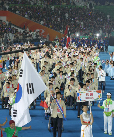 12일 중국 광저우 아오티 주경기장에서 열린 2010 광저우 장애인 아시안게임 개막식, 배드민턴 김기연을 기수로 대한민국 선수단이 입장하고 있다.