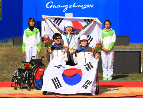 17일 중국 광저우 아오티 양궁장에서 열린 양궁 여자 리커브 단체전에서 중국을 이기고 금메달을 차지한 고희숙(왼쪽 앉은이부터 시계방향),이화숙, 김란숙이 시상식이 끝난 뒤 태극기를 들고 기념촬영을 하고 있다.