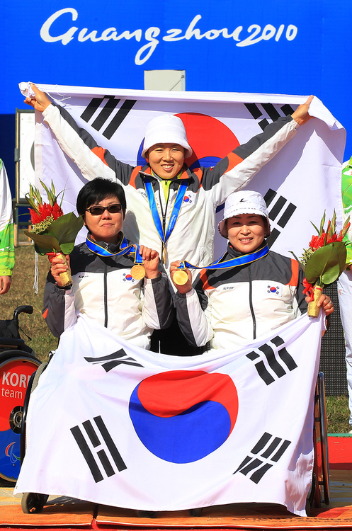 17일 중국 광저우 아오티 양궁장에서 열린 양궁 여자 리커브 단체전에서 중국을 이기고 금메달을 차지한 고희숙(왼쪽 앉은이부터 시계방향),이화숙, 김란숙이 시상식이 끝난 뒤 태극기를 들고 기념촬영을 하고 있다.