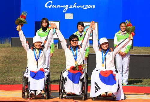 17일 중국 광저우 아오티 양궁장에서 열린 양궁 여자 리커브 단체전에서 중국을 이기고 금메달을 차지한 한국 대표팀 이화숙(왼쪽부터),고희숙, 김란숙이 시상식에서 손을 들어 인사하고 있다.