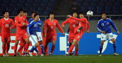 23일 오후 중국 충칭 올림픽 스타디움에서 열린 2008 동아시아 축구 선수권, 대한민국-일본의 경기에서 한국 선수들이 일본의 프리킥을 몸으로 막은 후 재빠르게 걷어내고 있다. 
