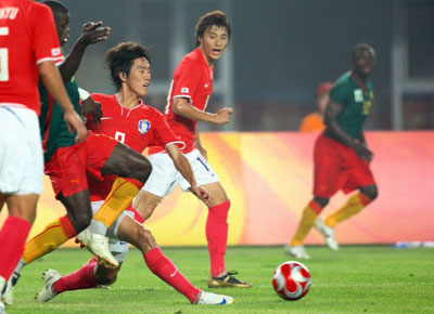 7일 중국 친황다오 올림픽스포츠센터 스타디움에서 열린 2008 베이징올림픽 남자 축구 D조 예선, 대한민국-카메룬 경기에서 한국 김정우가 넘어지면서 상대 공격을 차단하고 있다. 