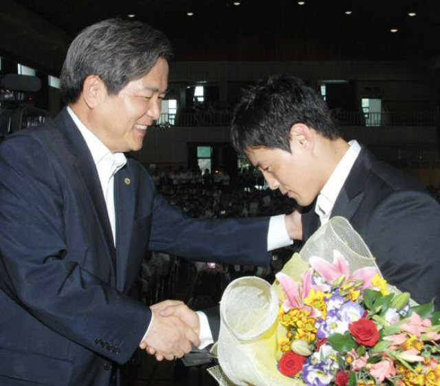 베이징올림픽에서 한국의 첫 금메달을 획득한 유도 최민호 선수 환영식이 28일 오후 경북 경산시 최 선수의 모교인 진량고교 체육관에서 열렸다. 최 선수(오른쪽)가 격려사를 한 최병국 경산시장과 악수하고 있다. 