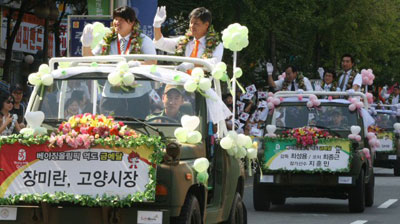 고양시는 28일 오후 일산서구 대화동 종합운동장 앞에서 2008 베이징올림픽 역도에서 금메달을 획득한 장미란 선수(고양시청)를 환영하는 카퍼레이드 행사를 벌였다. 사진은 장 선수와 강현석 고양시장이 함께 오픈카에 올라 시민들에게 손을 흔들어 보이고 있다. 