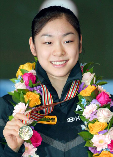 세계 최초로 피겨 여자 싱글 부문 200점을 돌파하며 세계선수권대회를 우승한 김연아가 31일 오후 인천국제공항을 통해 입국하며 팬들과 취재진을 향해 금메달을 들어 보이고 있다. 