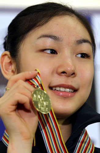  세계 최초로 피겨 여자 싱글 부문 200점을 돌파하며 세계선수권대회를 우승한 김연아가 31일 오후 인천국제공항을 통해 입국, 기자회견을 마친 뒤 취재진을 향해 금메달을 들어 보이고 있다. 