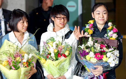세계 최초로 피겨 여자 싱글 부문 200점을 돌파하며 세계선수권대회를 우승한 김연아가 31일 오후 인천국제공항을 통해 입국하며 팬들과 취재진을 향해 손을 들어 인사하고 있다. 사진 왼쪽부터 김연아 선수 어머니 박미희 씨, 대표팀 후배 김민석, 김연아. 