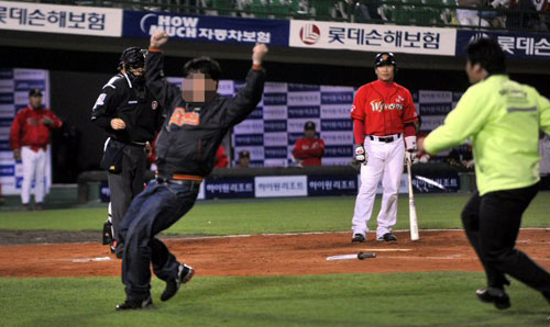 6일 부산 사직야구장에서 열린 2009 프로야구 롯데 자이언츠-SK 와이번스 경기, 7회초 SK 박재홍 타석 때 한 롯데팬이 그라운드에 난입해 경기가 잠시 중단되고 있다. 