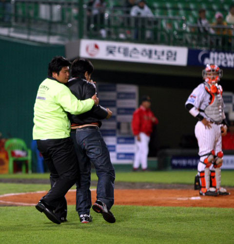 6일 부산 사직야구장에서 열린 2009 프로야구 롯데 자이언츠-SK 와이번스 경기, 7회초 SK 박재홍 타석 때 한 롯데팬이 그라운드에 난입해 경기가 잠시 중단되고 있다. 