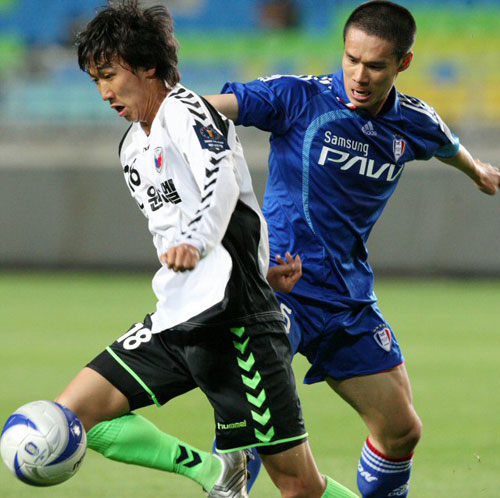 13일 수원월드컵경기장에서 열린 2009 하나은행 FA컵 수원 삼성-노원 험멜 경기, 수원 배기종(오른쪽)이 팀 동료 송종국에 이어 삭발을 한 채 상대 선수와 볼다툼을 하고 있다. 