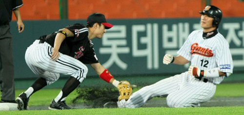 28일 부산 사직야구장에서 열린 2009 프로야구 롯데 자이언츠-LG 트윈스 경기, 롯데 김주찬(오른쪽)이 5회말 2루타성 타구를 날리고 3루까지 달리다 LG 3루수 정성훈에게 태그아웃 당하고 있다. 