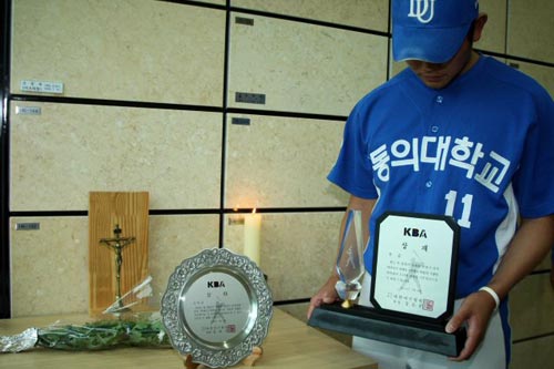  2009 전국대학야구 하계리그에서 성균관대를 물리치고 정상에 오른 동의대 야구팀 투수 문광은이 우승 상패를 들고 지난 4일 지병으로 별세한 고 조성옥 감독의 유해가 모셔져 있는 경남 양산의 하늘공원을 찾아 고개를 숙이고 있다. 