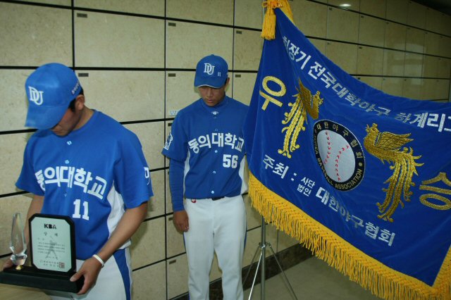 2009 전국대학야구 하계리그에서 성균관대를 물리치고 정상에 오른 동의대 야구팀 투수 문광은(왼쪽)과 주장 이인영이 각각 우승 상패와 우승기를 든 채 지난 4일 지병으로 별세한 고 조성옥 감독의 유해가 모셔져 있는 경남 양산의 하늘공원을 찾아 고개를 숙이고 있다. 