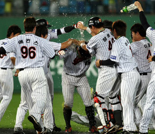  16일 부산 사직야구장에서 열린 프로야구 한화 대 롯데경기. 10회말 2사 만루에서 롯데 홍성흔이 끝내기 안타를 때린 뒤 동료로부터 음료수 세례를 받고 있다. 