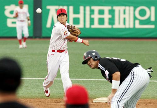 23일 광주 무등경기장에서 열린 2009 프로야구 KIA 타이거즈-LG 트윈스 경기, KIA 이현곤(왼쪽)이 LG 최동수가 몸을 숙이는 가운데 1루로 송구하고 있다. 