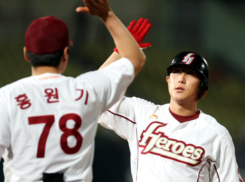30일 오후 서울 목동야구장에서 열린 2009 프로야구 히어로즈와 SK의 경기 4회말 1사 2,3루 상황에서 히어로즈 황재균이 동점타를 날린 뒤 홍원기 코치와 하이파이브를 하고 있다. 
