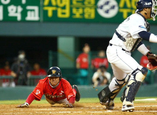 31일 서울 잠실야구장에서 열린 2009 프로야구 두산과 SK의 경기에서 5회초 1사 2루 상황에서 SK 정상호의 적시타를 틈타 2루주자 나주환이 몸을 날려 선취점을 올리고 있다. 