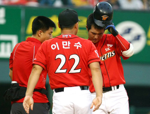31일 서울 잠실야구장에서 열린 2009 프로야구 두산과 SK의 경기에서 4회초 1사 상황에서 SK 타자 최정이 자신이 친 파울볼에 무릎을 맞고 응급조치를 마치자 이만수 코치가 상태를 묻고 있다. 