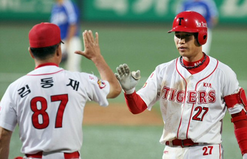 KIA 타이거즈 김상훈이 2일 광주 무등경기장 야구장에서 열린 `2009 프로야구' 삼성 라이온스와의 홈경기에서 7회말 2사 주자 1,3루때 역전 적시타를 치고 1루에서 김동재 코치와 하이파이브를 하고 있다. 