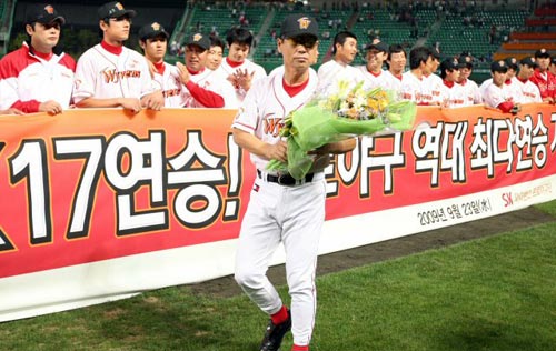 23일 인천 문학구장에서 열린 2009 프로야구 SK 와이번스-삼성 라이온즈 경기, SK 김성근 감독이 삼성을 7대4로 꺾고 한국 프로야구 최다 연승 기록인 17연승을 달성한 후 축하 꽃다발을 받고 선수들과 함께 기뻐하고 있다. 