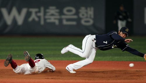  23일 서울 목동야구장에서 열린 2009 프로야구 히어로즈-두산 베어스 경기, 히어로즈 대주자 장기영(왼쪽)이 2루 도루를 시도하는 가운데 두산 오재원이 최승환 포수의 악송구를 잡기 위해 몸을 날리고 있다. 