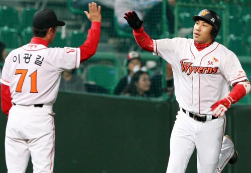 25일 인천 문학구장에서 열린 2009 프로야구 SK 와이번스-두산 베어스 경기, SK 김강민이 1회말 7대 1로 달아나는 1점 홈런을 친 후 이광길 3루 코치와 하이파이브를 하고 있다. 