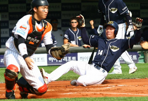 2일 오후 부산 사직구장에서 열린 2009 프로야구 준플레이오프 3차전 롯데와 두산의 경기 1회초 2사 주자1,2루 상황에서 타석에 들어선 두산 최준석의 적시타 때 고영민이 홈을 밟고 있다. 