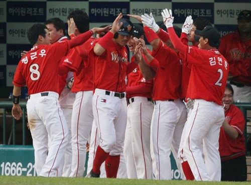 11일 서울 잠실야구장에서 열린 2009 프로야구 플레이오프 4차전 두산과 SK의 경기 7회초 2사 1.2루에서 SK 김강민의 2타점 3루타로 박정권이 홈을 밟은 뒤 축하받고 있다. 