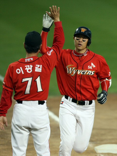 SK 최정이 11일 오후 서울 잠실구장에서 열린 2009 프로야구 플레이오프 4차전 두산 베어스와 경기 8회초 1사 주자없는 상황에서 좌중월 1점홈런을 때린 뒤 이광길 코치와 하이파이브를 하고 있다. 