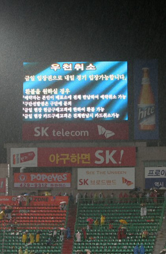 13일 인천 문학구장에서 열린 프로야구 플레이오프 5차전 SK와이번스-두산베어스 2회초에 폭우로 경기가 중단되자 전광판에 '우천취소' 공고가 방영되고 있다. 