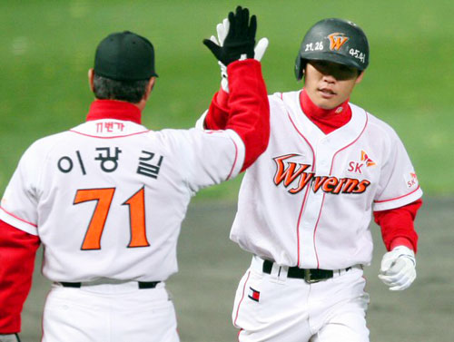 19일 오후 인천 문학구장에서 열린 2009 프로야구 한국시리즈 3차전 SK 와이번스-KIA 타이거즈 경기. SK 조동화가 8회말 무사 주자없는 상황에서 오른쪽 담장을 넘는 1점홈런을 때린 뒤 이광길코치의 축하를 받고 있다. 