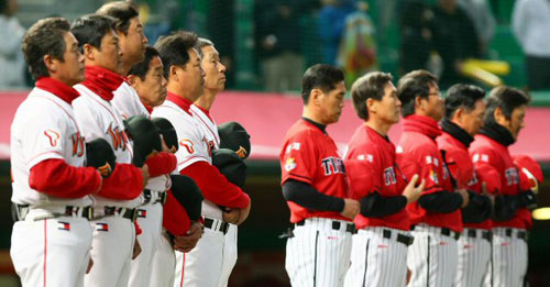  19일 인천 문학야구장에서 열린 2009 한국시리즈 3차전 SK 와이번스와 기아 타이거즈와의 경기에서 SK 김성근 감독과 기아의 조범현 감독을 비롯한 양팀 코칭 스태프가 국민의례를 하고 있다. 