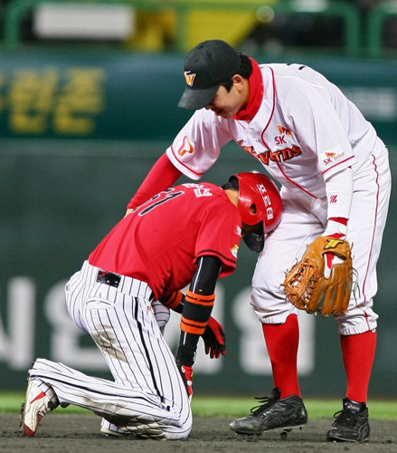 20일 인천 문학구장에서 열린 2009 프로야구 한국시리즈 4차전 SK 와이번스와 기아 타이거즈와의 경기에서 SK의 유격수 나주환이 기아의 김원섭이 3회초 찬스에서 장성호의 내야땅볼로 더블플레이를 당한 뒤 고개를 숙이고 있자 등을 다독이며 일어나라고 말하고 있다. 