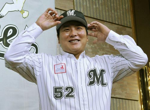 일본프로야구 지바 롯데 마린스와 계약한 김태균(오른쪽)이 16일 일본 지바현에 있는 한 호텔에서 열린 입단식에 참석, 모자와 유니폼을 입고 있다. 