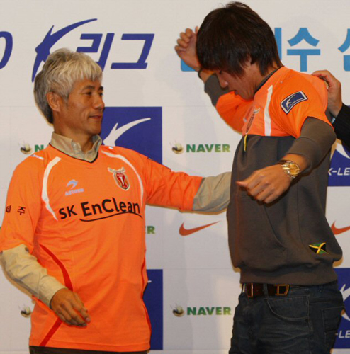 홍명보호 U-20월드컵대표팀 홍정호가 17일 서울 그랜드힐튼 호텔에서 열린 2010년도 K-리그 신인선수선발 드래프트에서 제주 유나이티드 선수로 1순위 1번으로 지명받고 나서 박경훈 감독의 도움을 받아 유니폼을 입고 있다. 