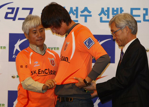 홍명보호 U-20월드컵대표팀 홍정호가 17일 서울 그랜드힐튼 호텔에서 열린 2010년도 K-리그 신인선수선발 드래프트에서 제주 유나이티드 선수로 1순위 1번으로 지명받고 나서 박경훈 감독의 도움을 받아 유니폼을 입고 있다. 